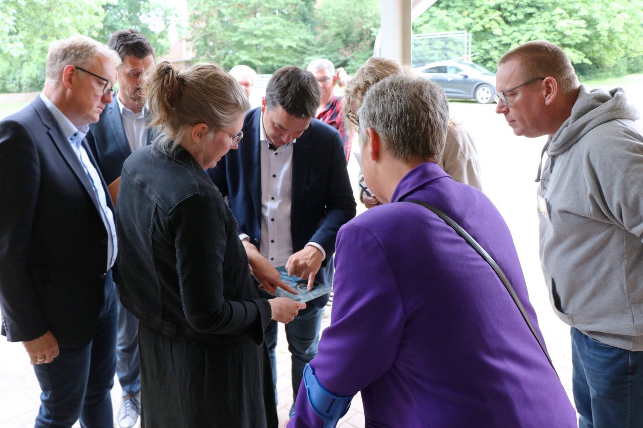 Landtagspräsidentin Naber mit einigen weiteren Personen über eine Karte gebeugt.