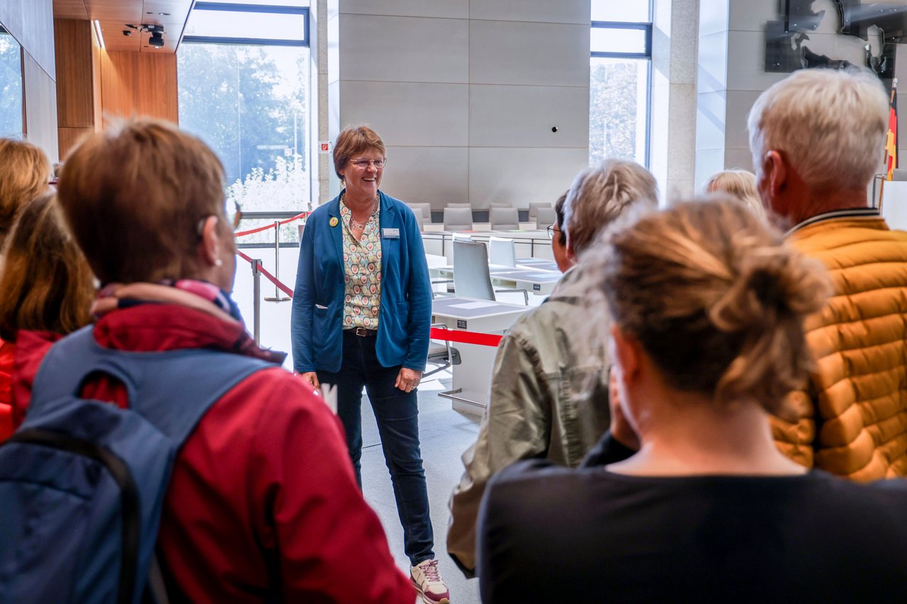 Landtagsvizepräsidentin Meta Janssen-Kucz mit einigen Besucherinnen und Besuchern im Plenarsaal