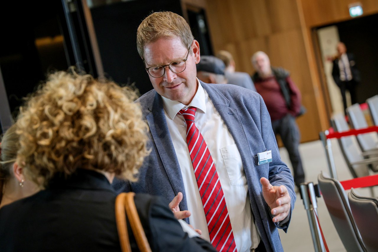 Landtagsvizepräsident Marcus Bosse im Gespräch mit einer Besucherin im Plenarsaal