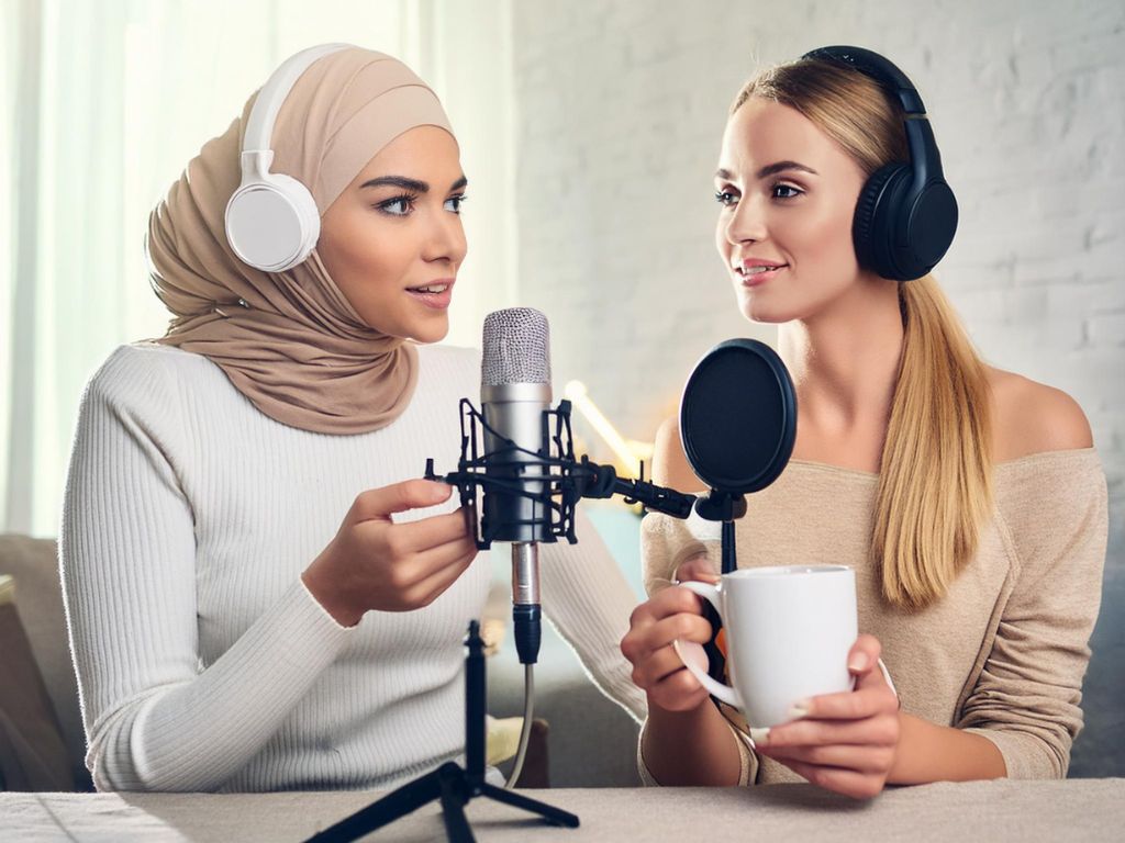  KI-generiertes Bild: Zwei Frauen mit Kopfhörern an einem Mikro, eine der Frauen trägt Kopftuch.