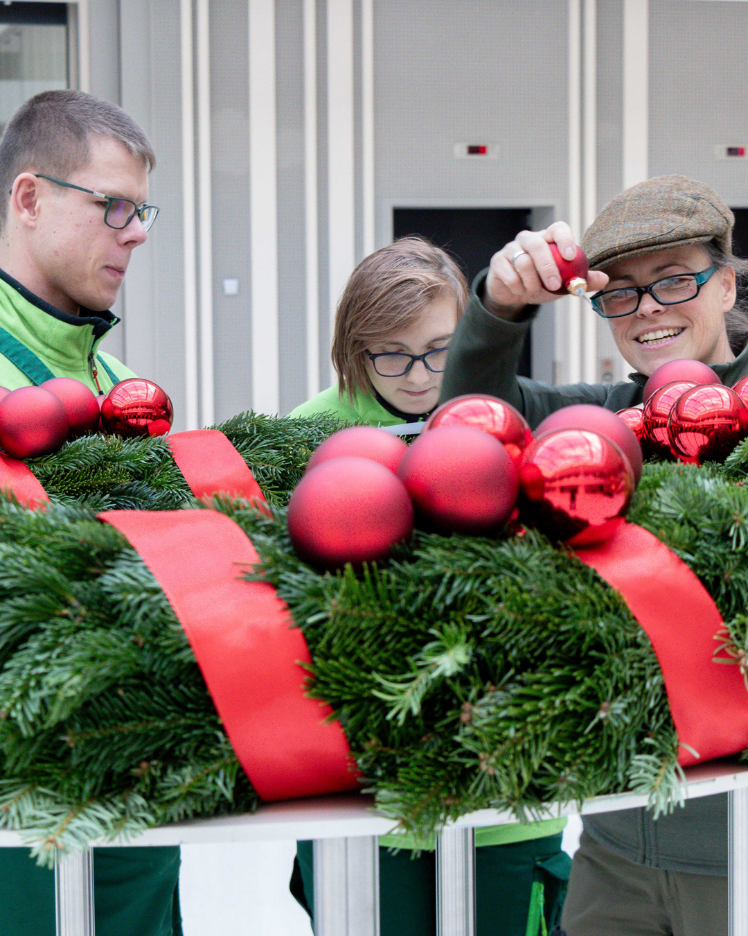 Mitarbeitende der Evangelischen Stiftung Neuerkerode schmücken den Adventskranz.